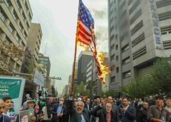 מסלול התנגשות. איראנים מציתים את דגל ארה"ב מול בניין השגרירות האמריקנית לשעבר בטהרן. צילום: גטי אימג'ס
