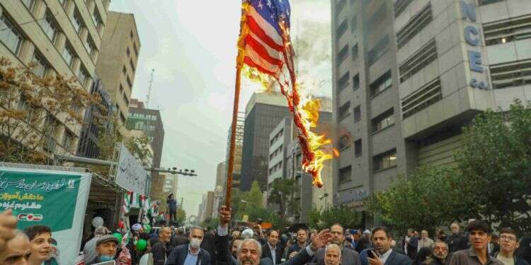 מסלול התנגשות. איראנים מציתים את דגל ארה מסלול התנגשות. איראנים מציתים את דגל ארה"ב מול בניין השגרירות האמריקנית לשעבר בטהרן. צילום: גטי אימג'ס