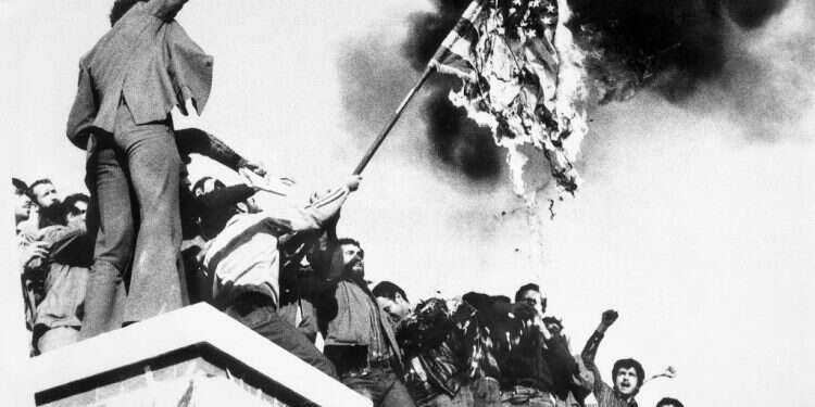 מפגינים איראנים על חומת השגרירות האמריקנית בטהרן, 1979. צילום: גטי אימג'ס מפגינים איראנים על חומת השגרירות האמריקנית בטהרן, 1979. צילום: גטי אימג'ס