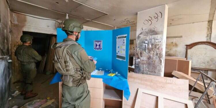 לוחם צה"ל מצביע בבחירות לרשויות המקומיות, בקלפי צבאית בשכונת זייתון בעזה. צילום: אסף גבור