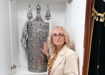 רחלי פריקר לצד ספר תורה בבית הכנסת בבארי