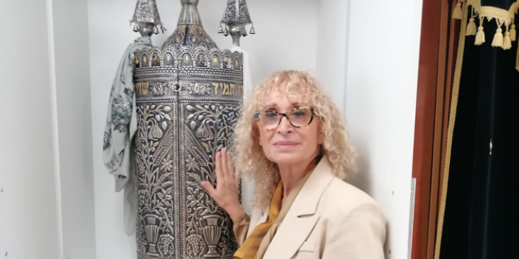 רחלי פריקר לצד ספר תורה בבית הכנסת בבארי