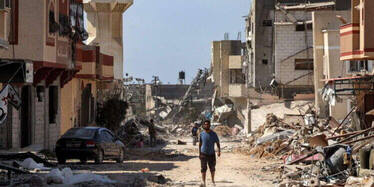 פלסטינים בחורבות חאן יונס. צילום: AFP פלסטינים בחורבות חאן יונס. צילום: AFP