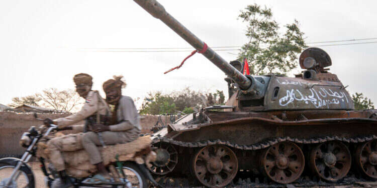 חיילי RSF חולפים על פני טנק הרוס של הכוחות המזוינים של סודאן במערב דארפור. צילום: Diana Zeyneb Alhindawi, Washington Post חיילי RSF חולפים על פני טנק הרוס של הכוחות המזוינים של סודאן במערב דארפור. צילום: Diana Zeyneb Alhindawi, Washington Post