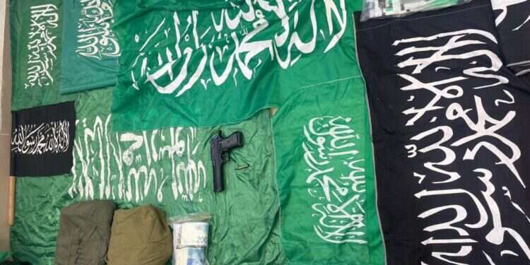 דגלי חמאס ודאעש והאקדח שנמצאו אצל בני הזוג ממזרח ירושלים. צילום: דוברות המשטרה עשרות דגלי חמאס ודאעש נמצאו אצל זוג מירושלים