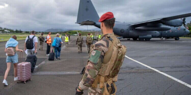 המרד בקלדוניה החדשה. חייל ניו־זילנדי מאבטח השבוע תיירים שנמלטים מהארכיפלג במטוס צבאי מיוחד. צילום: איי.אף.פי המרד בקלדוניה החדשה. חייל ניו־זילנדי מאבטח השבוע תיירים שנמלטים מהארכיפלג במטוס צבאי מיוחד. צילום: איי.אף.פי