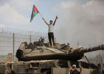 מחבלים עומדים על טנק צה"ל בוער ב-7 באוקטובר