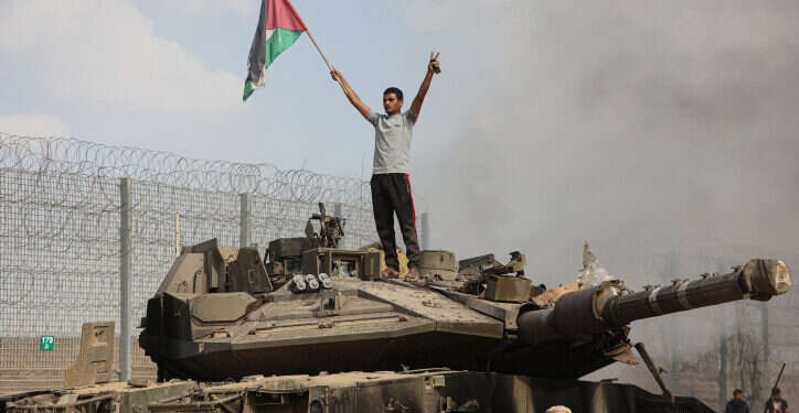 מחבלים עומדים על טנק צה מחבלים עומדים על טנק צה"ל בוער ב-7 באוקטובר