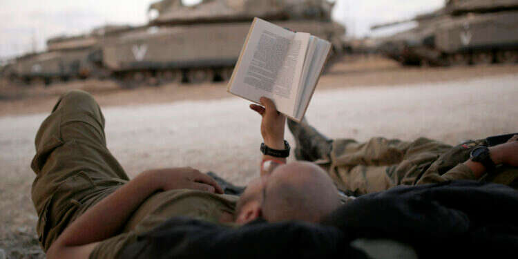חייל ישראלי קורא ספר בגבול רצועת עזה. צילום: אמיר כהן - רויטרס חייל ישראלי קורא ספר בגבול רצועת עזה. צילום: אמיר כהן - רויטרס