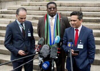 עוזר שר החוץ הפלסטיני עמר חיג'אזי (שמאל) ליד נציגי דרופ אפריקה בהאג, בחדוש שעבר. צילום: Nick Gammon / AFP הרשות הפלסטינית ביקשה להצטרף לתביעה נגד ישראל בהאג