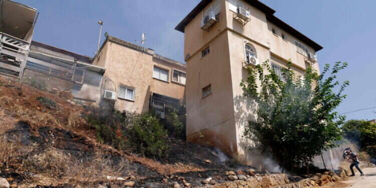 שריפות סמוך למבנים בקריית שמונה בעקבות התקפות חיזבאללה. צילום: AFP במלחמה בצפון לישראל יש הרבה יותר מה להפסיד