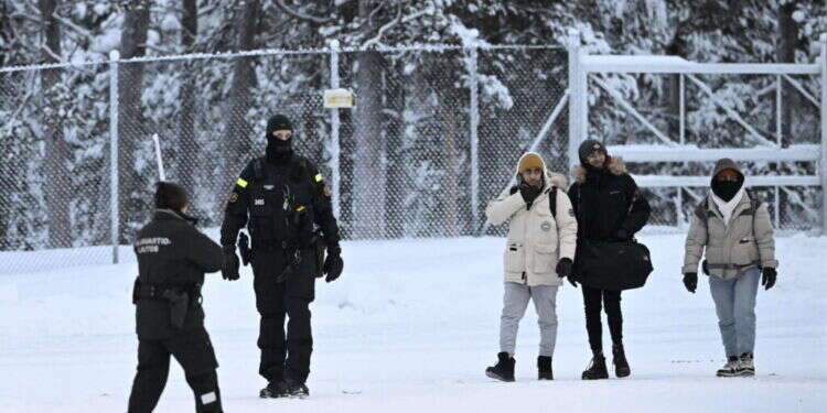 אנשי משמר הגבול של פינלנד עם מהגרים בגבול עם רוסיה. צילום: Emmi Korhonen / Lehtikuva / AFP "לוחמה היברידית של רוסיה": פינלנד נאבקת במסתננים – למרות החוק הבינלאומי