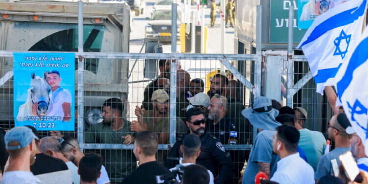 Right-wing Israelis demonstrate next to the Sde Teman military base near Beersheba, against the detention for questioning of military reservists who were suspected of harming Hamas militants arrested after taking part in the October 7 attack on Israel, on July 29, 2024. (Photo by Menahem Kahana / AFP) ארגון חוננו: המחבל המתלונן היה מ"פ בעיירה ג'באליה