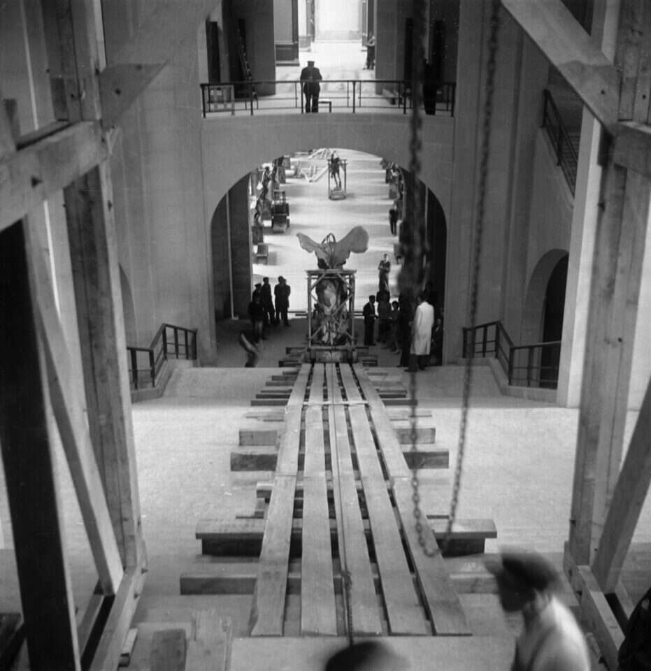 שובו של הניצחון ממלתעות התבוסה, 1945. עובדי הלובר מחזירים את הפסל "ניקה מסמותרקיה", המתאר את אלת הניצחון היוונית, למקומו במעלה גרם המדרגות של הלובר. זוהי מחווה להורדתו למחתרת, על כבש עץ דומה, ערב פריצת המלחמה. צילום: גטי אימג'ס