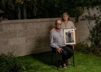 ירון ורבקה שור בביתם בירושלים השבוע, עם תמונתו של ברקאי. צילום: נעמה שטרן