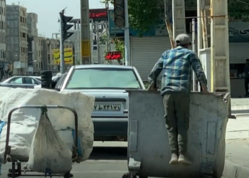 צעיר קופץ לפח כדי לחפש אוכל בטהראן. צילום מיוטיוב