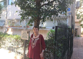 מאביה למדה על חשיבותם של ספרים. פרופ' גוברין ליד בית ילדותה. בשלט מוזכר אביה, הסופר והעורך ישראל כהן. צילום: יאיר בן־חיים