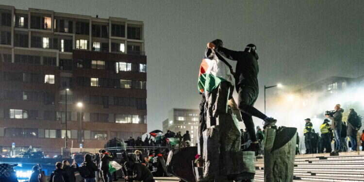 תומך חמאס עם דגל פלסטין באמסטרדם, למחרת הפוגרום. צילום: AFP תומך חמאס עם דגל פלסטין באמסטרדם, היום. צילום: AFP