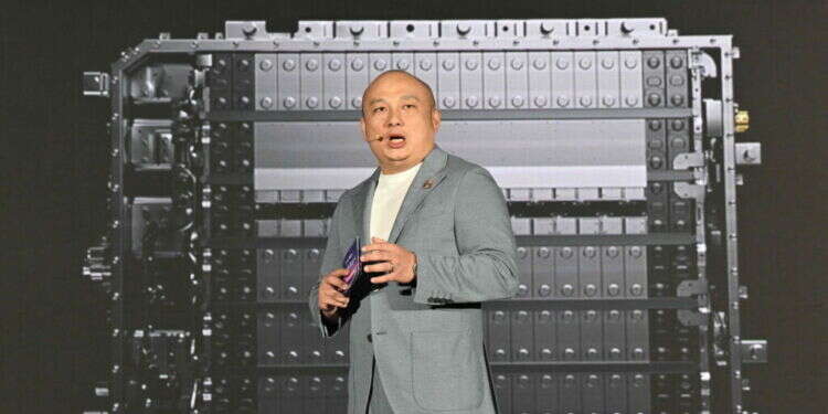 ראש אגף הטכנולוגיה בחרבת CATL, על רקע הסוללה. צילום: AFP הענקית הסינית מציגה: סוללה שמחזיקה 1,000 ק"מ ושורדת התנגשות של 120 קמ"ש