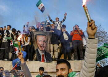 פליטים סורים בטורקיה חוגגים את מפלתו של אסד תוך שהם מנופפים בתמונתו של ארדואן. צילום: אי.אף.פי