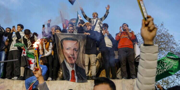 פליטים סורים בטורקיה חוגגים את מפלתו של אסד תוך שהם מנופפים בתמונתו של ארדואן. צילום: אי.אף.פי