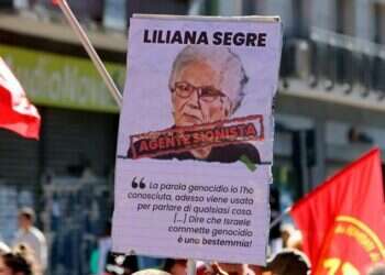 כרזה שהונפה בהפגנה באיטליה ועליה דמותה של שורדת השואה ליליאנה סגרה עם הכיתוב "סוכנת ציונית". צילום מסך מיוטיוב