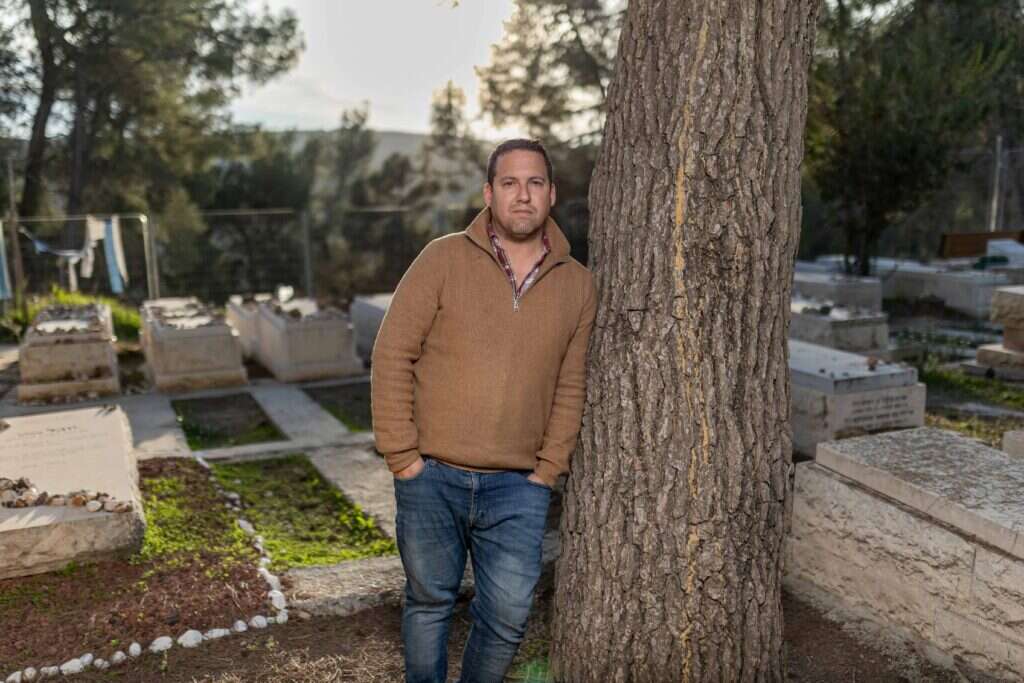 איתן פולד ליד קברו של ארי בבית הקברות בכפר־עציון, השבוע. צילום: נעמה שטרן
