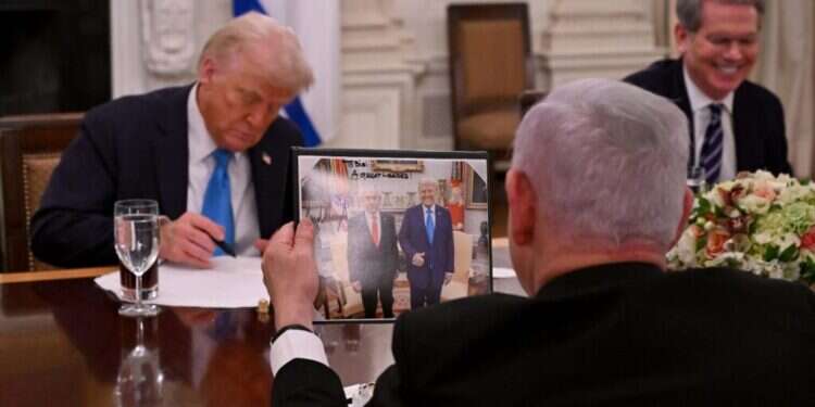 נתניהו אוחז בתמונה שקיבל מטראמפ ועליה נכתב "לביבי - מנהיג גדול". צילום: אבי אוחיון, לע"מ