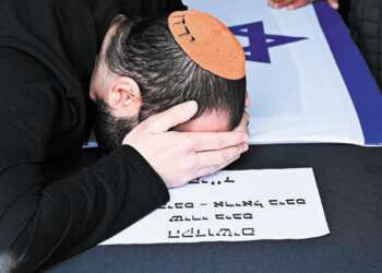 ירדן ביבס מעל הארון של שירי, אריאל וכפיר. צילום: איתן אונר