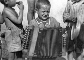 ילד מנגן בגטו לודז'. ארכיון יד ושם